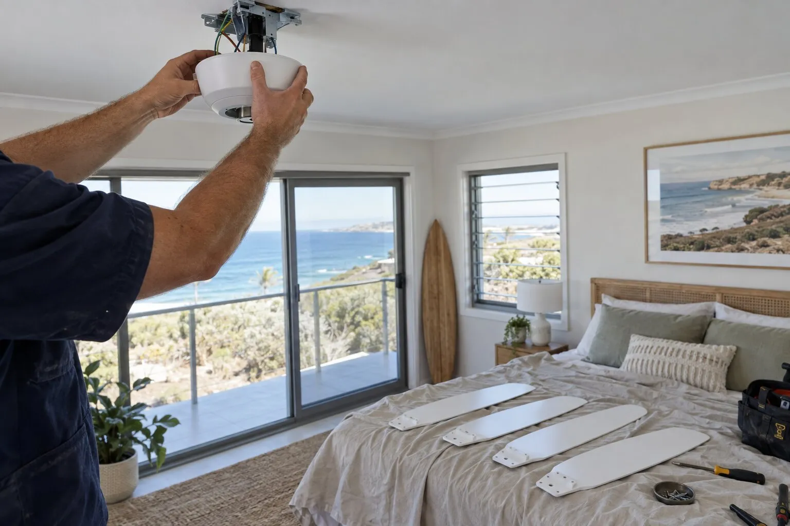 Electrician connecting a ceiling fan canopy to a ceiling mounting bracket